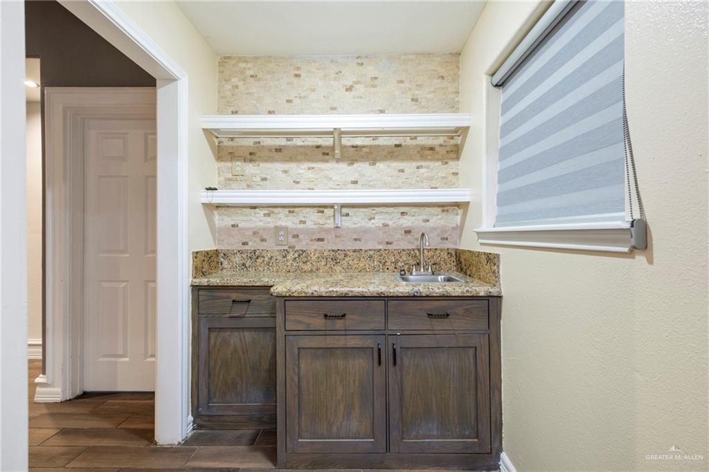 105 East Hawk Avenue McAllen, TX 78504 - Photo 11 of 34 a bathroom with a granite countertop sink and a mirror