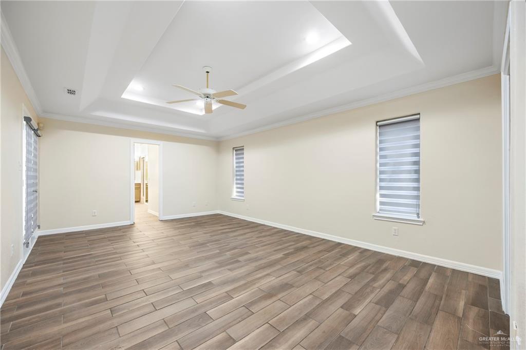 105 East Hawk Avenue McAllen, TX 78504 - Photo 12 of 34 an empty room with wooden floor and windows
