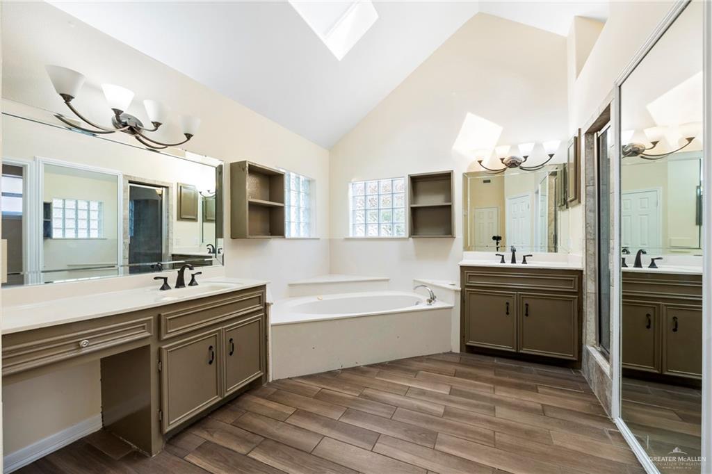 105 East Hawk Avenue McAllen, TX 78504 - Photo 15 of 34 a large bathroom with a large tub sink vanity and mirror