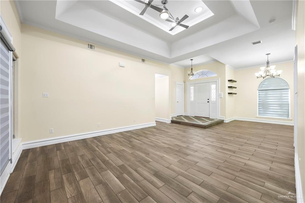 105 East Hawk Avenue McAllen, TX 78504 - Photo 2 of 34 an empty room with wooden floor and windows