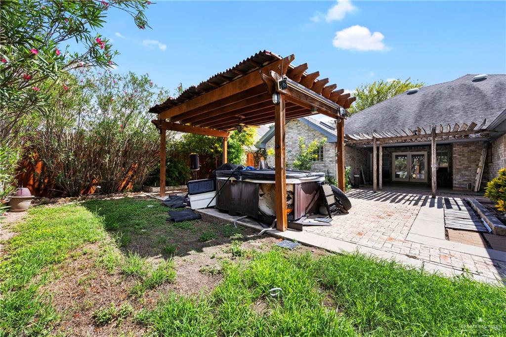105 East Hawk Avenue McAllen, TX 78504 - Photo 24 of 34 a view of a patio with a table and chairs under an umbrella with a small yard
