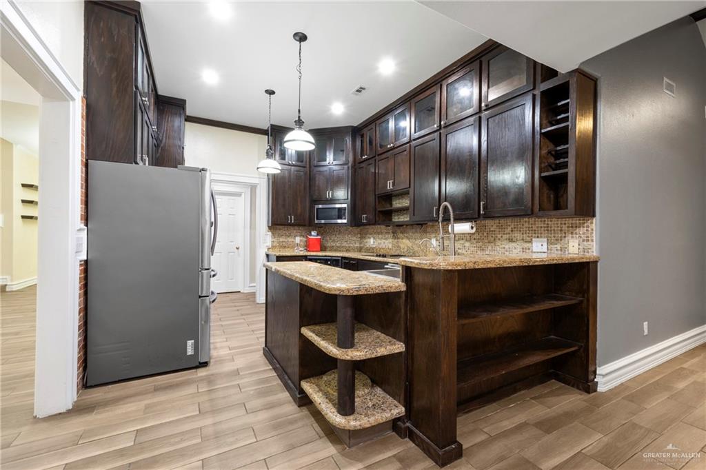 105 East Hawk Avenue McAllen, TX 78504 - Photo 5 of 34 a kitchen with stainless steel appliances kitchen island granite countertop a refrigerator and a sink