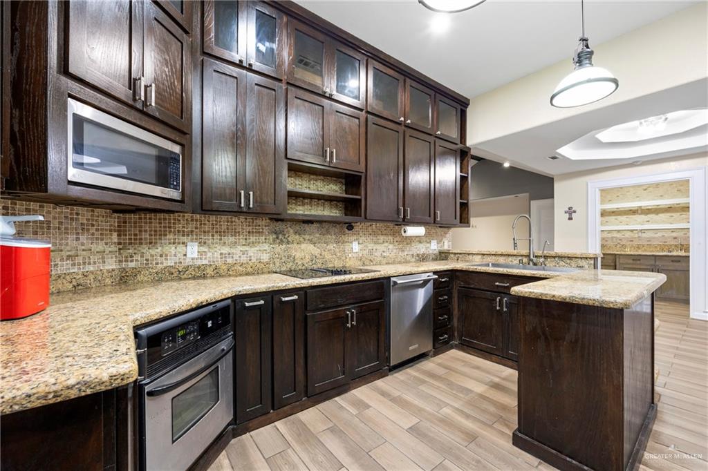 105 East Hawk Avenue McAllen, TX 78504 - Photo 6 of 34 a kitchen with stainless steel appliances granite countertop a sink stove and microwave