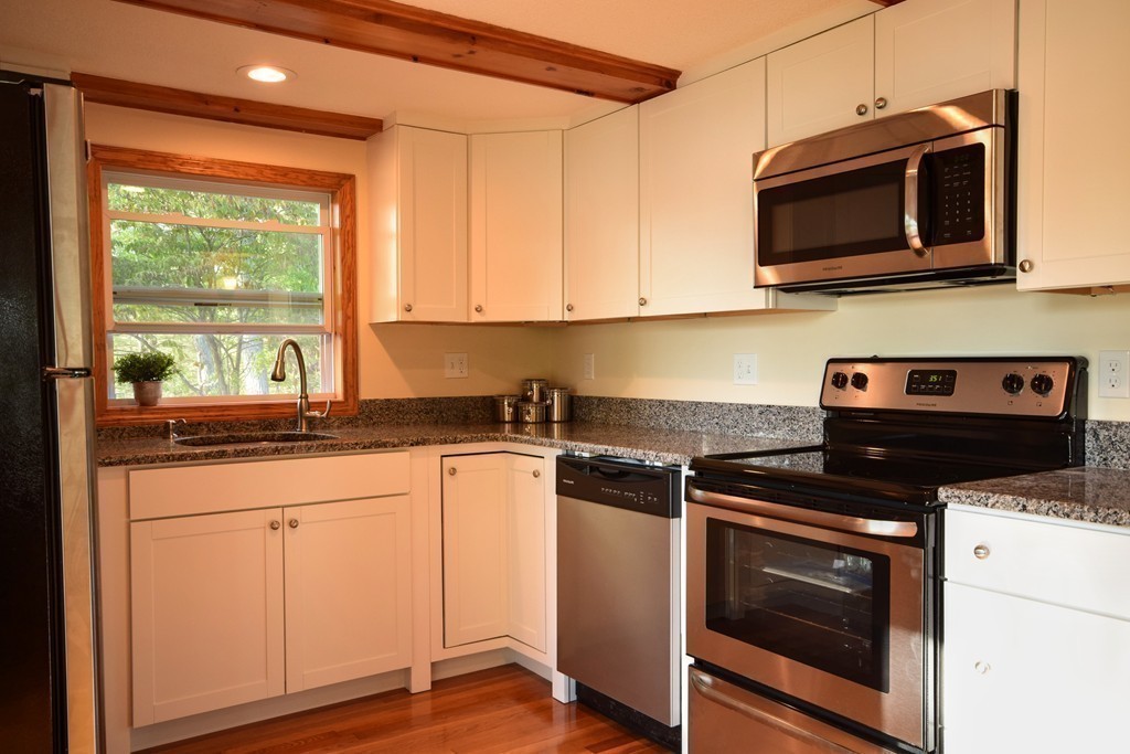 89 Lakeview Avenue Bellingham, MA 02019 - Photo 12 of 30 a kitchen with stainless steel appliances granite countertop a stove microwave and cabinets