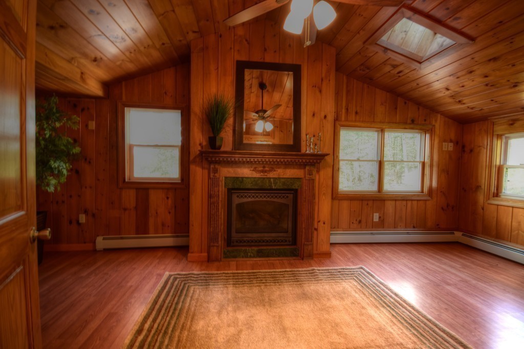 89 Lakeview Avenue Bellingham, MA 02019 - Photo 14 of 30 a view of an empty room with exposed radiator and fireplace