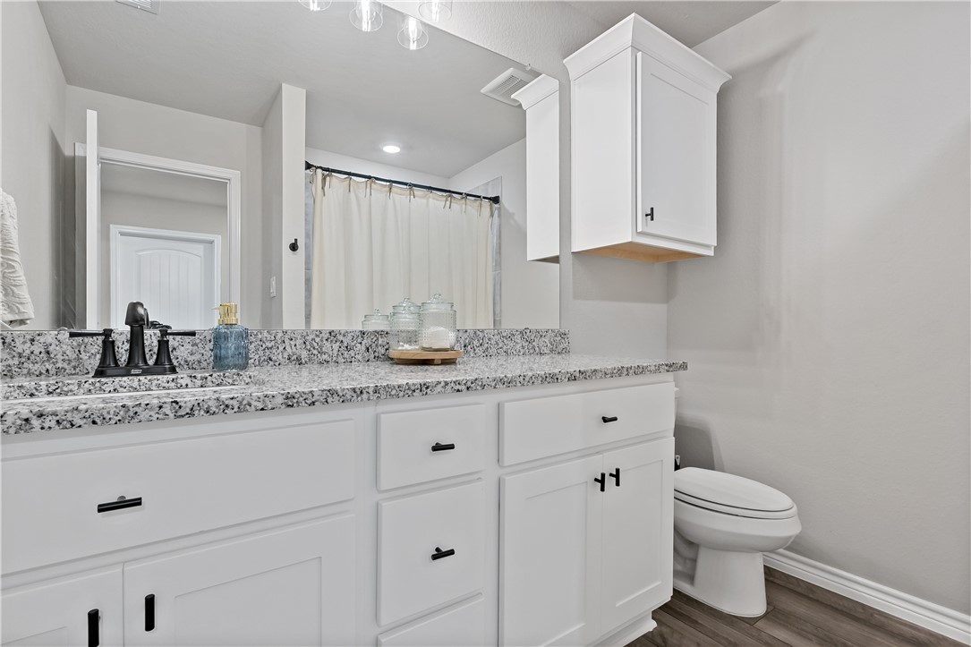 2135 Chief Street Bryan, TX 77807 - Photo 20 of 26 a bathroom with a granite countertop sink toilet and a mirror