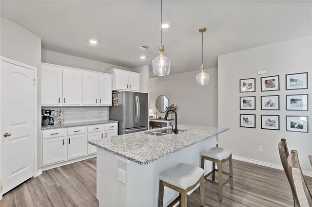 a kitchen with a table chairs refrigerator and microwave