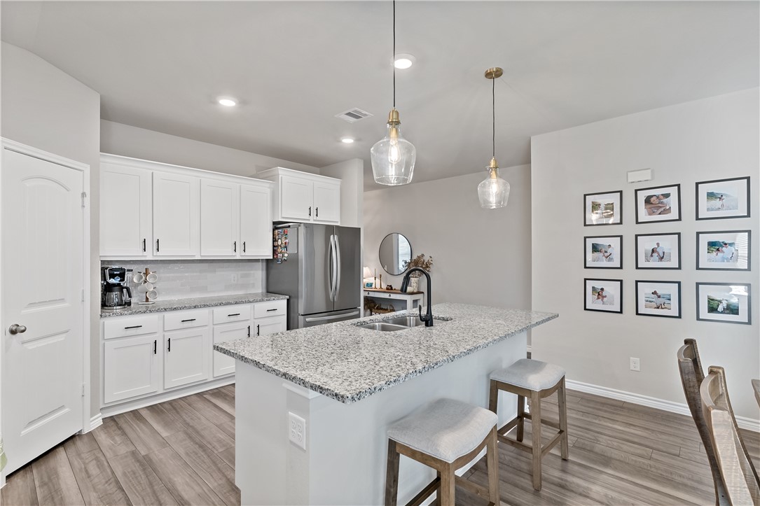 2135 Chief Street Bryan, TX 77807 - Photo 7 of 26 a kitchen with a table chairs refrigerator and microwave