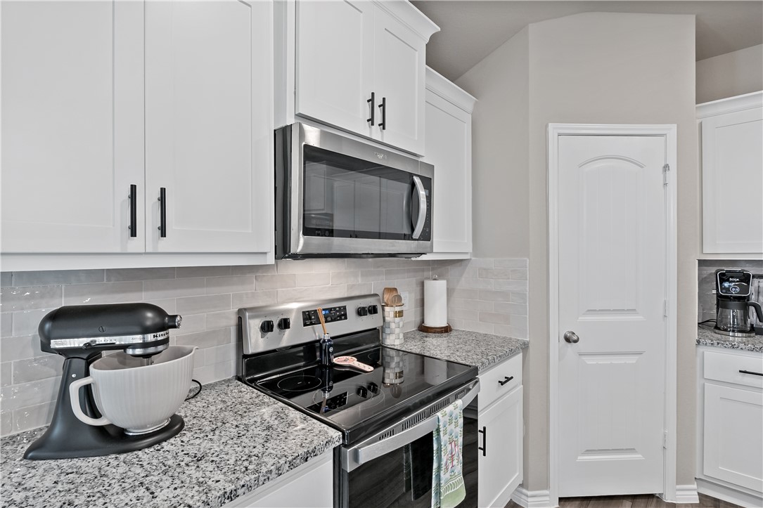 2135 Chief Street Bryan, TX 77807 - Photo 8 of 26 a kitchen with a stove and a microwave
