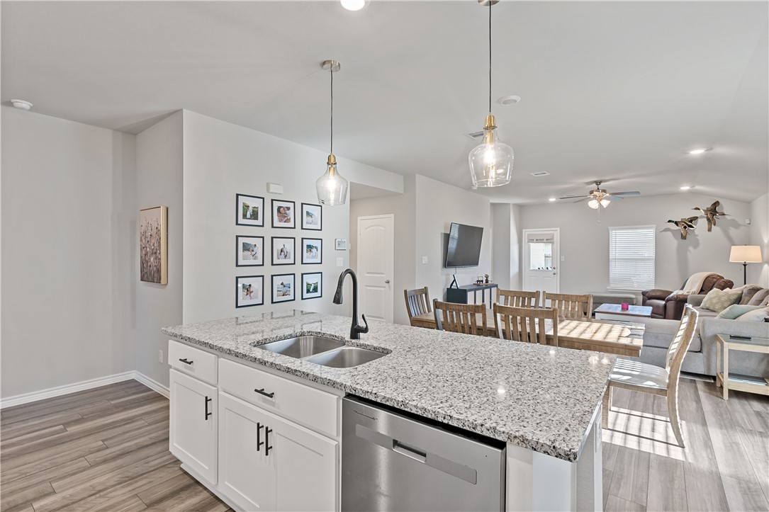 2135 Chief Street Bryan, TX 77807 - Photo 10 of 26 an open kitchen with granite countertop a sink and chandelier