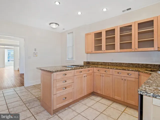 a kitchen with granite countertop white cabinets and appliances