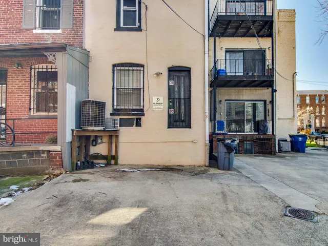 a view of a house with barbeque and wooden fence