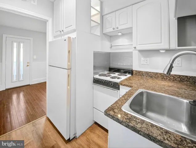 a kitchen with granite countertop a refrigerator sink and stove