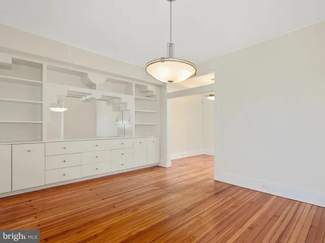 a view of a room with wooden floor and white walls
