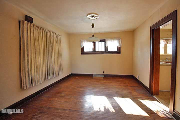 898 North Henderson Road Freeport, IL 61032 - Photo 6 of 19 a view of an empty room with wooden floor and a window