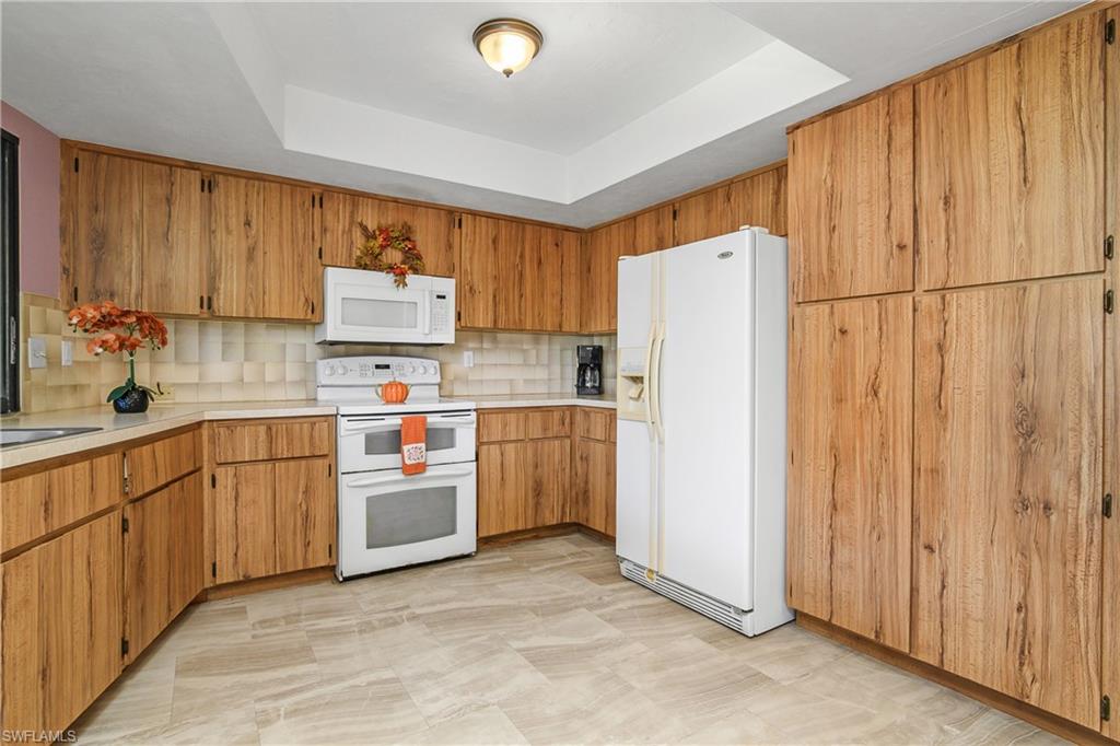 191 Round Key Circle, Unit D2 Naples, FL 34112 - Photo 13 of 24 a kitchen with stainless steel appliances granite countertop a refrigerator sink and cabinets