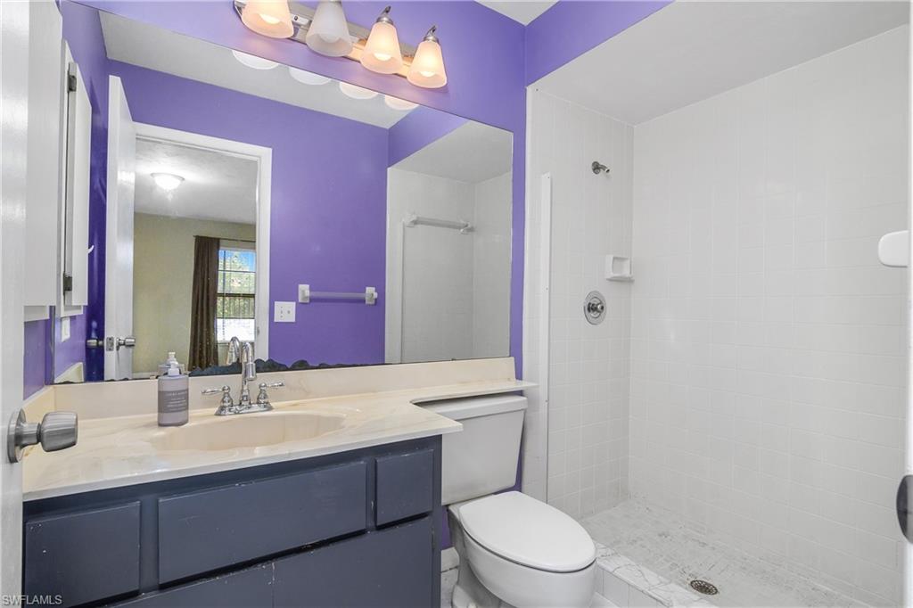 191 Round Key Circle, Unit D2 Naples, FL 34112 - Photo 23 of 24 a bathroom with a sink a toilet a mirror and shower