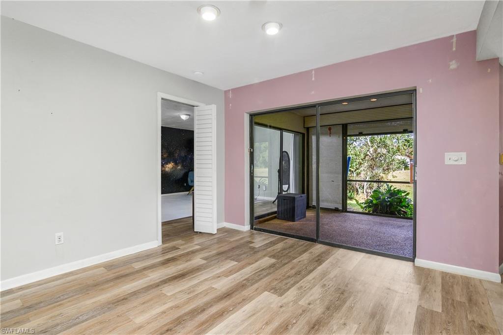 191 Round Key Circle, Unit D2 Naples, FL 34112 - Photo 8 of 24 a view of an empty room with wooden floor and a window