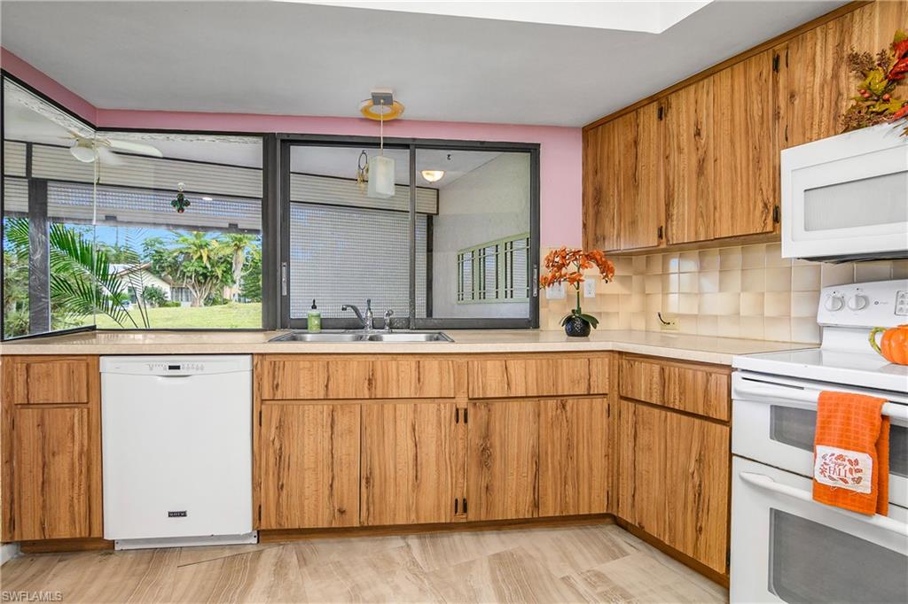191 Round Key Circle, Unit D2 Naples, FL 34112 - Photo 10 of 24 a kitchen with stainless steel appliances granite countertop a refrigerator sink and cabinets