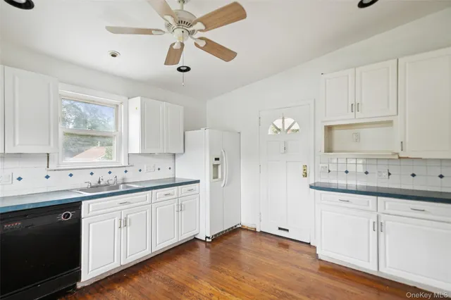 a kitchen with a sink cabinets and wooden floor