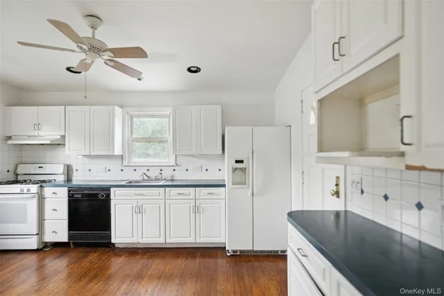 a kitchen with stainless steel appliances granite countertop a sink a stove and a refrigerator