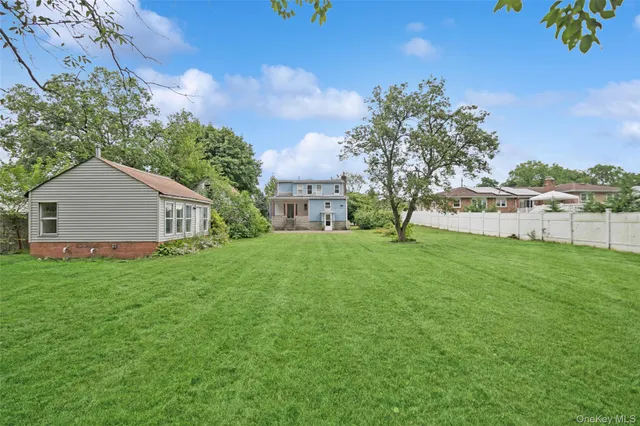 a view of backyard of house with green space