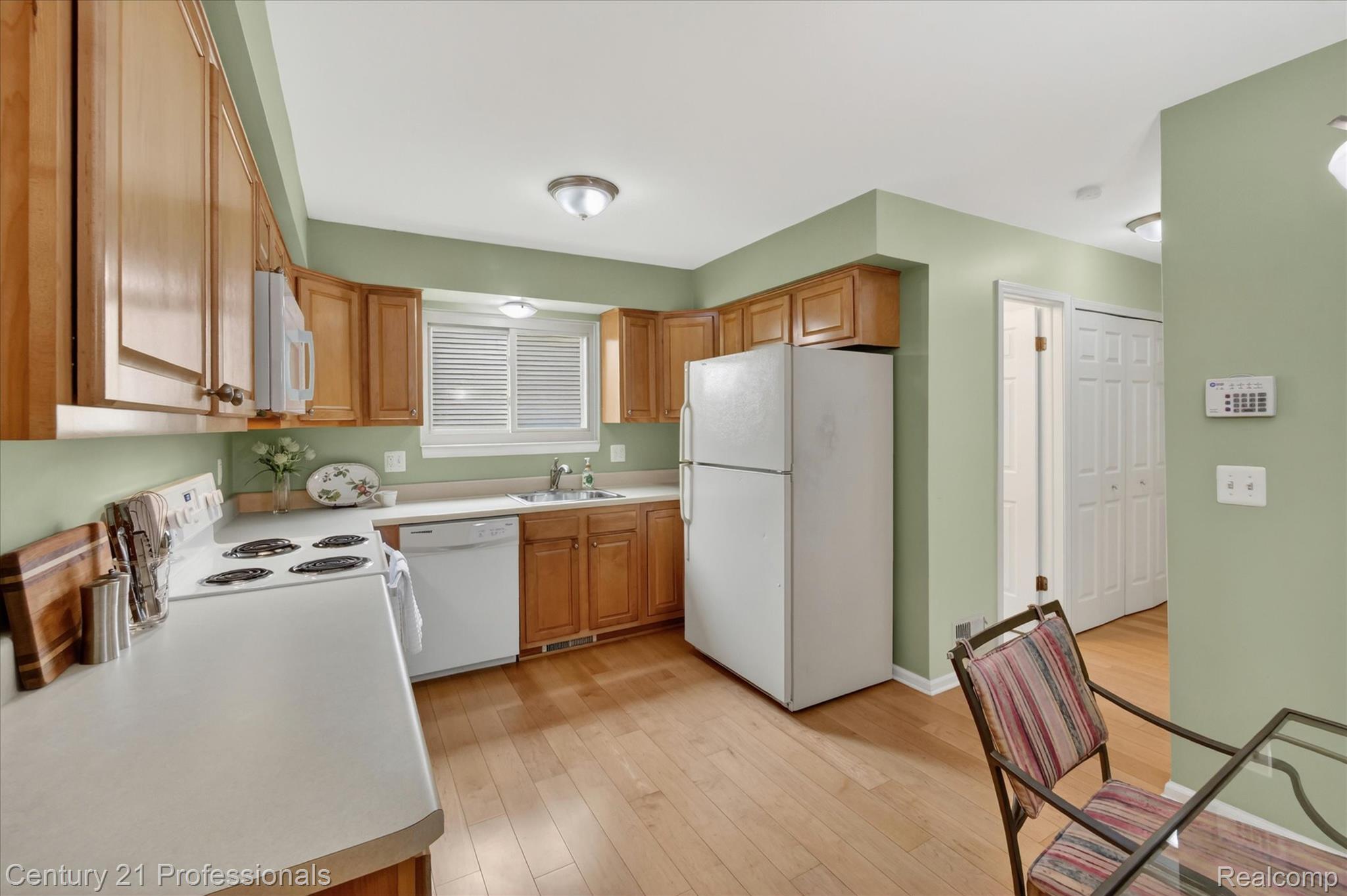 134 Foxboro Drive Rochester, MI 48309 - Photo 11 of 39 Kitchen with white appliances, wood finish cabinetry, light wood-style floors, and light countertops