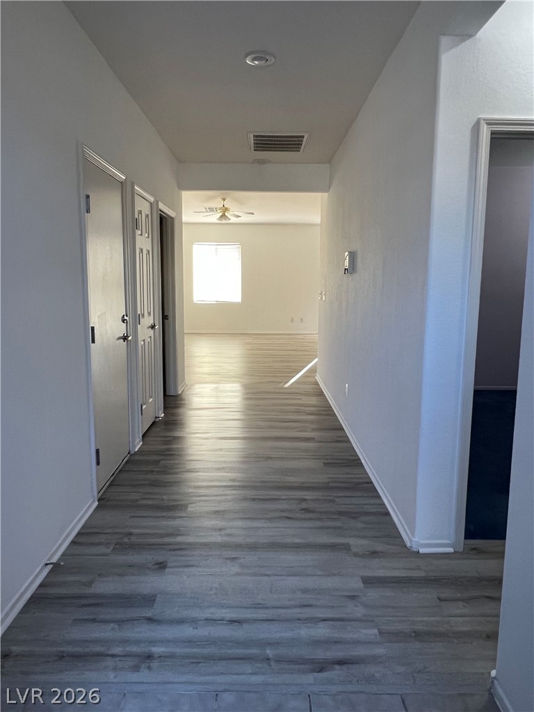 6472 Centennial Road Pahrump, NV 89048 - Photo 28 of 33 A lengthy, well-lit hall with durable plank flooring leads toward sun-filled interiors.