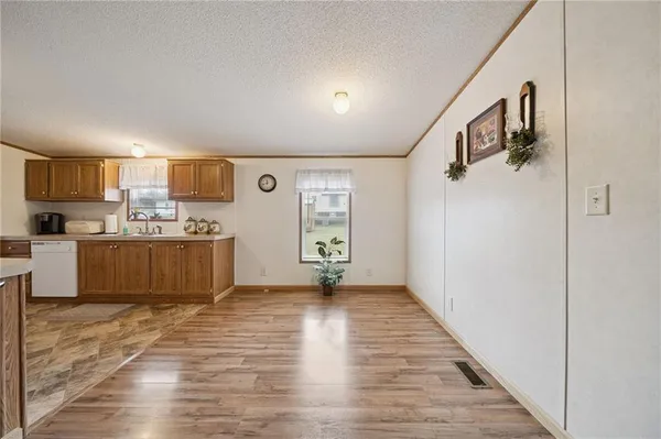 a view of a kitchen with wooden floor and electronic appliances