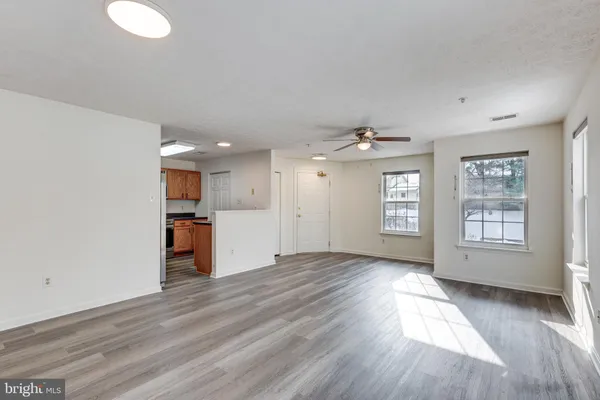 a view of a livingroom with a ceiling fan wooden floor and window