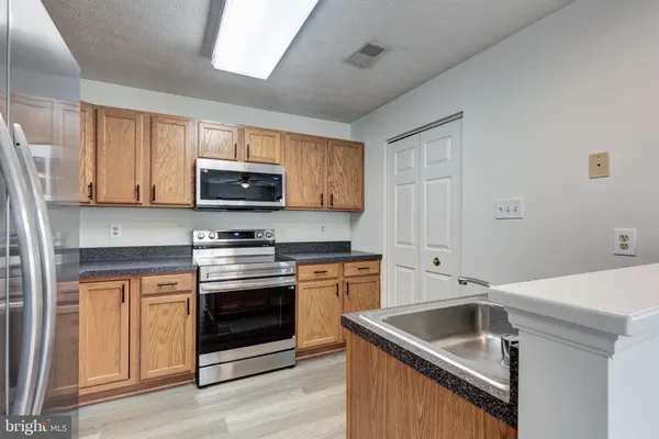 a kitchen with stainless steel appliances granite countertop a refrigerator stove and sink