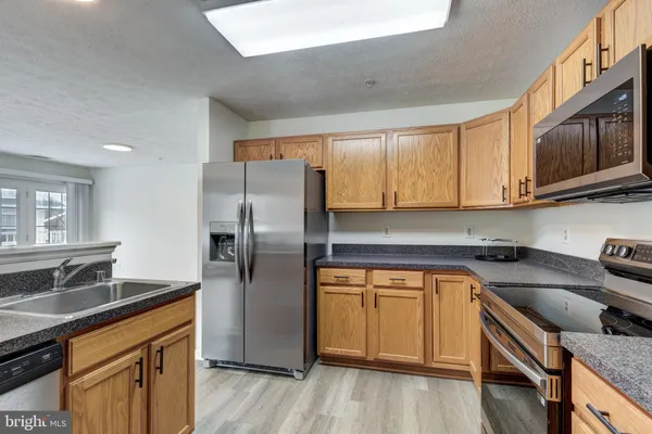 a kitchen with stainless steel appliances granite countertop white cabinets stove a sink and dishwasher