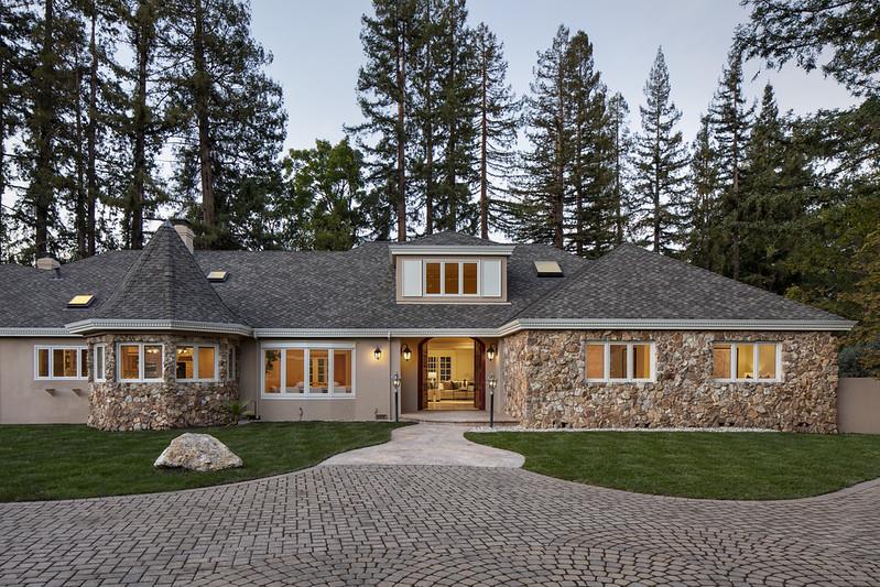 a front view of a house with a yard and trees