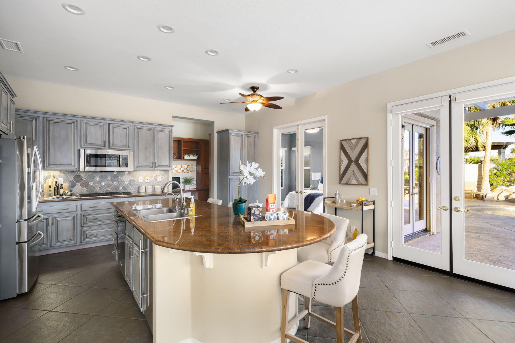 3 Pyramid Lake Court Rancho Mirage, CA 92270 - Photo 15 of 40 a kitchen with kitchen island granite countertop a sink a center island stainless steel appliances cabinets and a counter top space