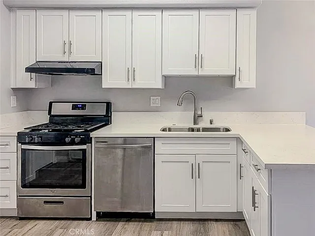 a kitchen with white cabinets and appliances