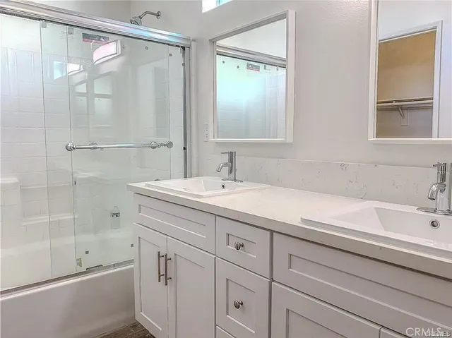 a bathroom with a shower sink and mirror