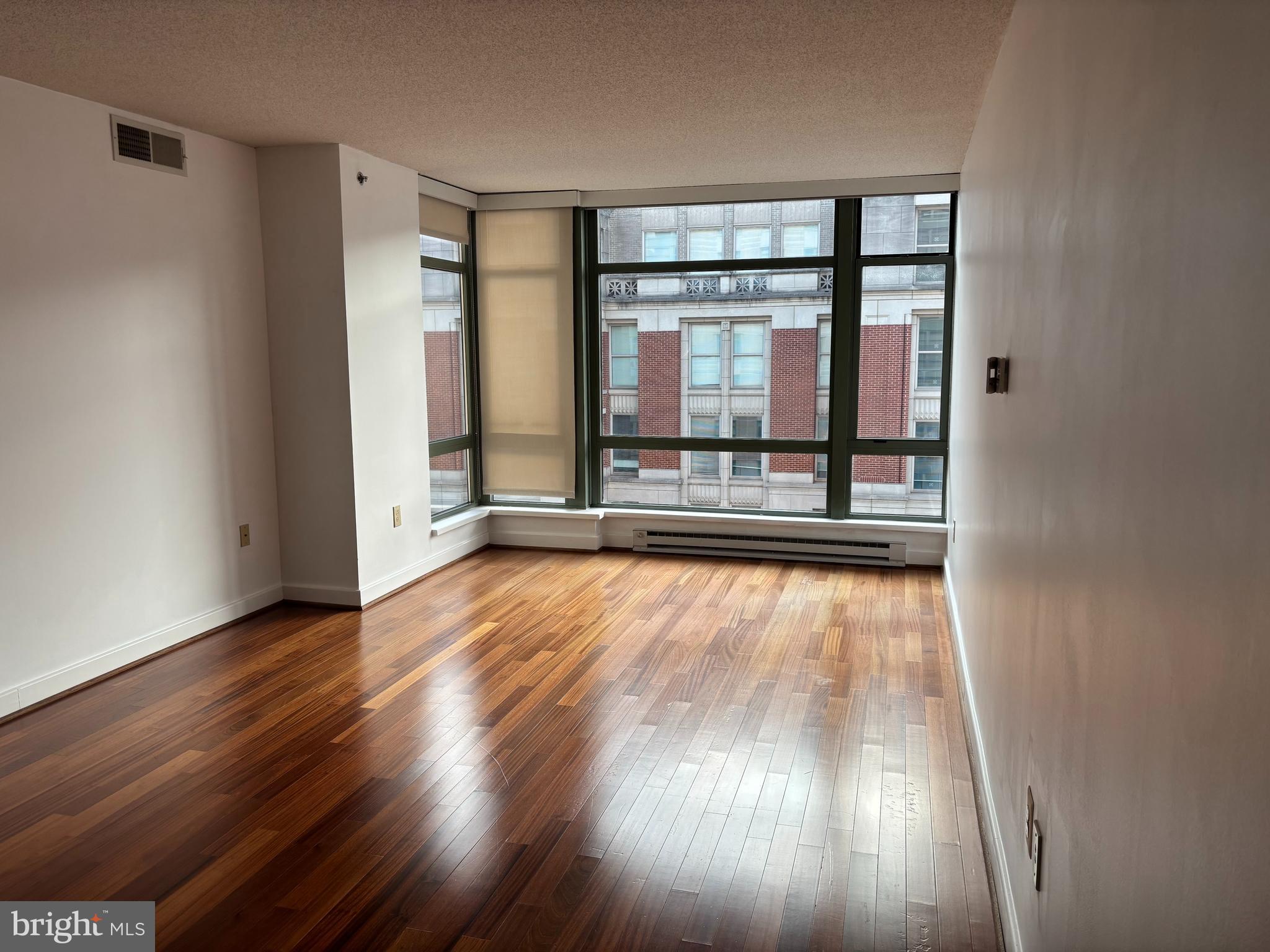 1150 K Street Northwest, Unit 1107 Washington, DC 20005 - Photo 4 of 20 wooden floor in an empty room with a window
