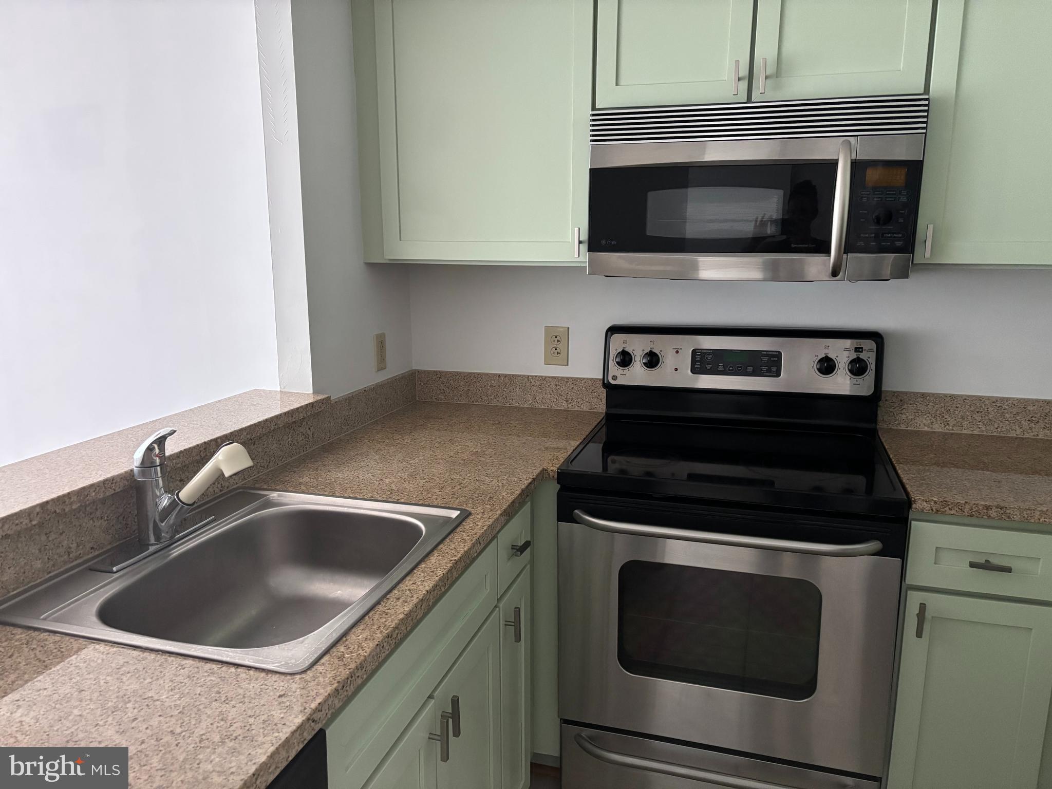 1150 K Street Northwest, Unit 1107 Washington, DC 20005 - Photo 6 of 20 a kitchen with a stove microwave and sink