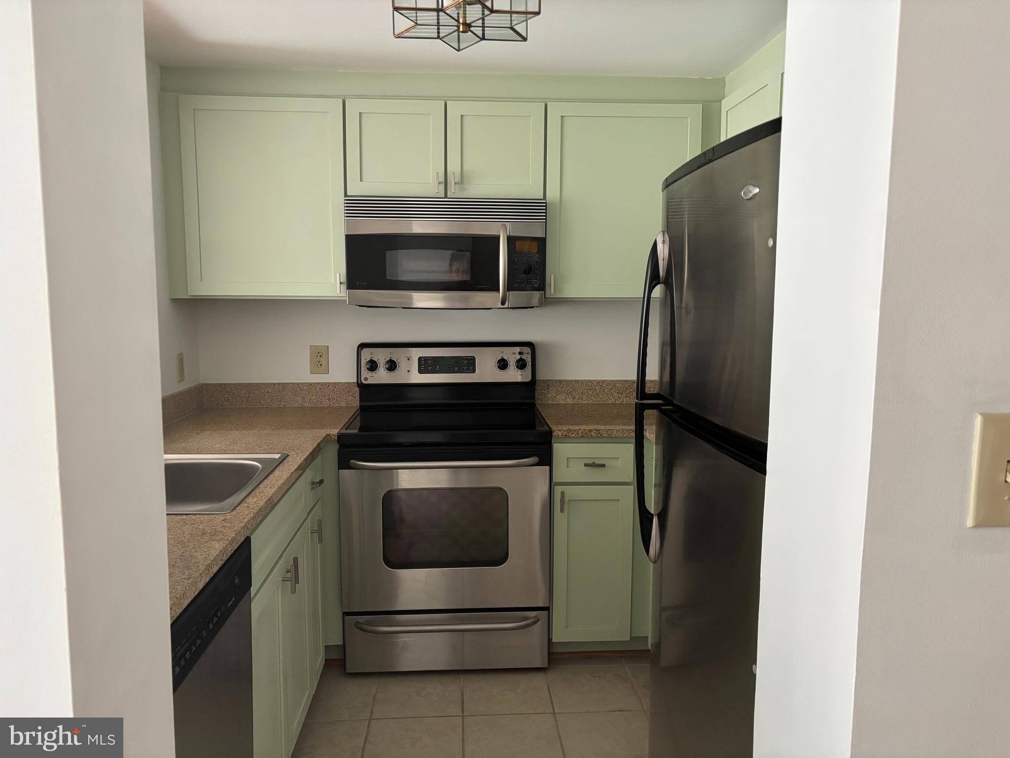 1150 K Street Northwest, Unit 1107 Washington, DC 20005 - Photo 7 of 20 a kitchen with stainless steel appliances granite countertop a refrigerator stove and microwave
