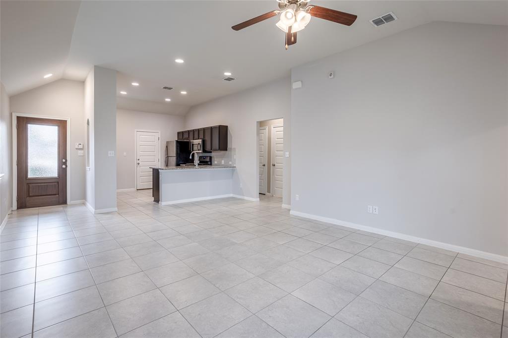 615 Stampede Road San Marcos, TX 78666 - Photo 3 of 26 A spacious, naturally illuminated living area seamlessly connects to a contemporary kitchen, ideal for entertaining.