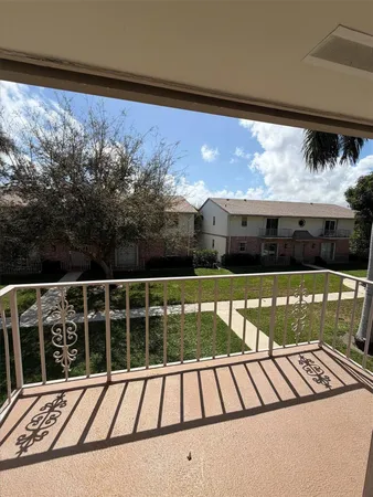 a view of a balcony with a floor to ceiling window next to a yard