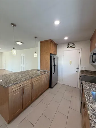 a kitchen with granite countertop a refrigerator and a sink