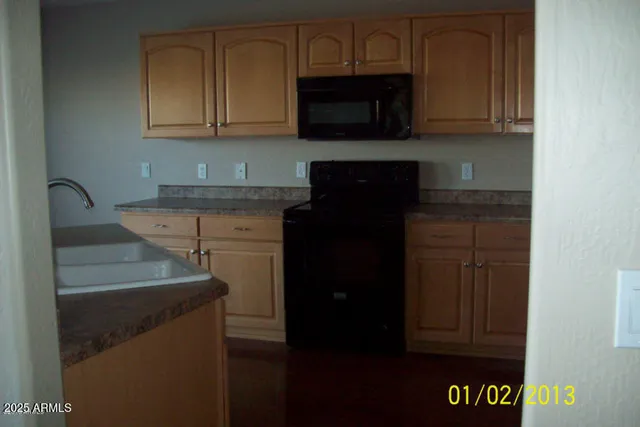 a kitchen with granite countertop wood cabinets and black appliances