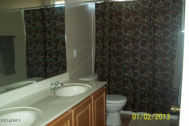 a bathroom with a granite countertop toilet and a sink