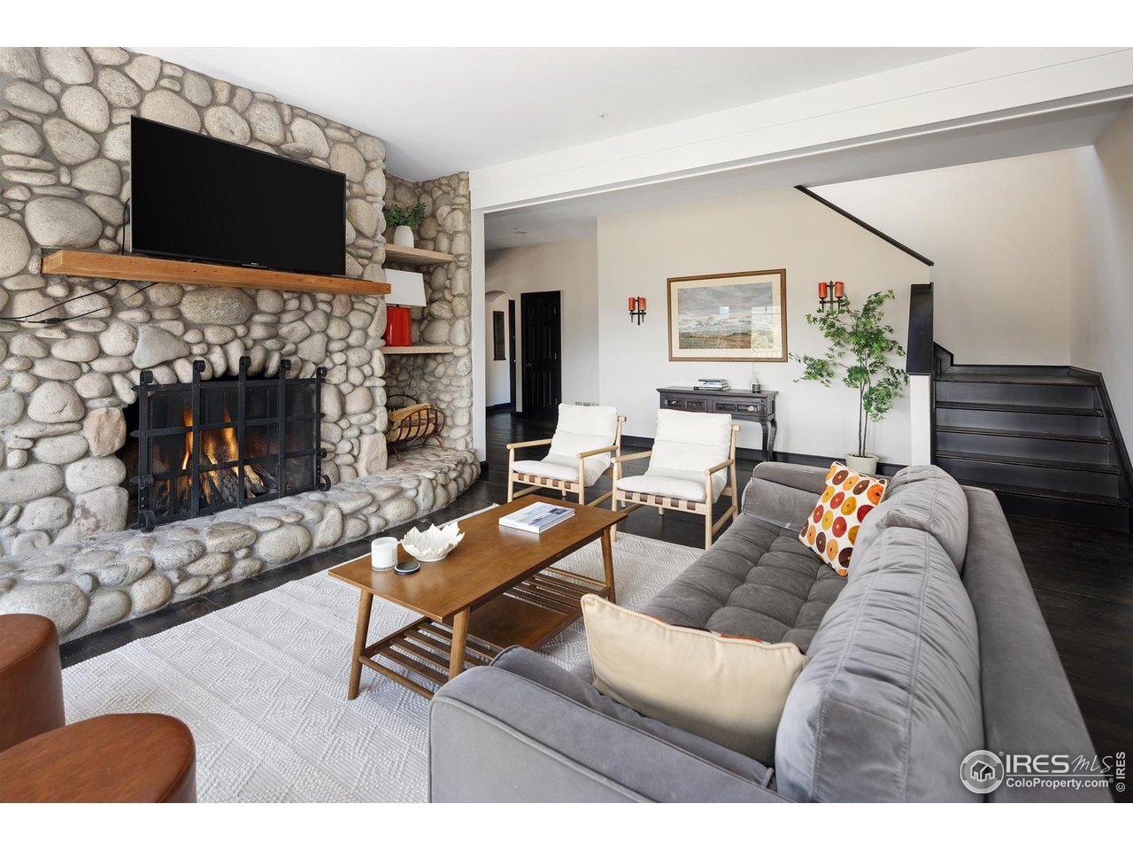 8558 Flagstaff Road Boulder, CO 80302 - Photo 17 of 50 a living room with furniture a flat screen tv and a fireplace