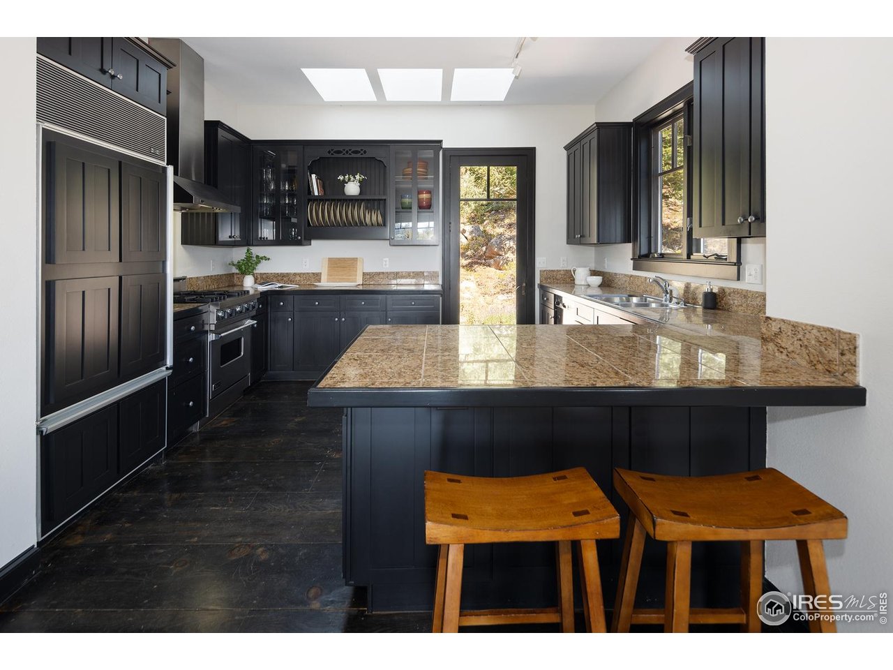 8558 Flagstaff Road Boulder, CO 80302 - Photo 21 of 50 a kitchen with stainless steel appliances kitchen island granite countertop wooden cabinets and granite counter tops