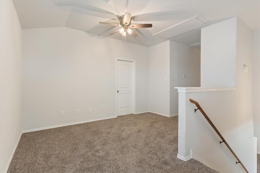 6317 Elephant Butte Drive Waco, TX 76708 - Photo 16 of 39 Carpeted room featuring a ceiling fan with light fixture, vaulted ceiling, and a paneled door