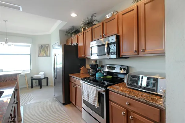 a kitchen with stainless steel appliances granite countertop a sink stove and refrigerator