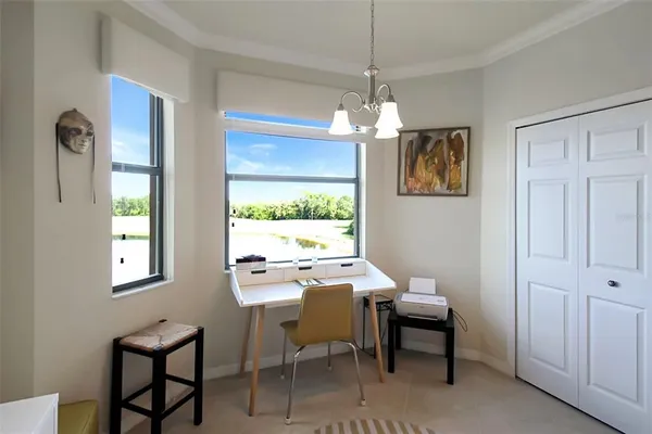 a view of a dining room with furniture a chandelier and a window