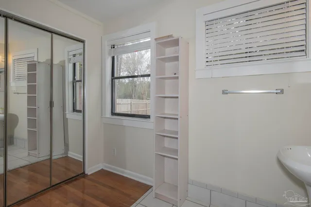 an empty room with wooden floor and closet